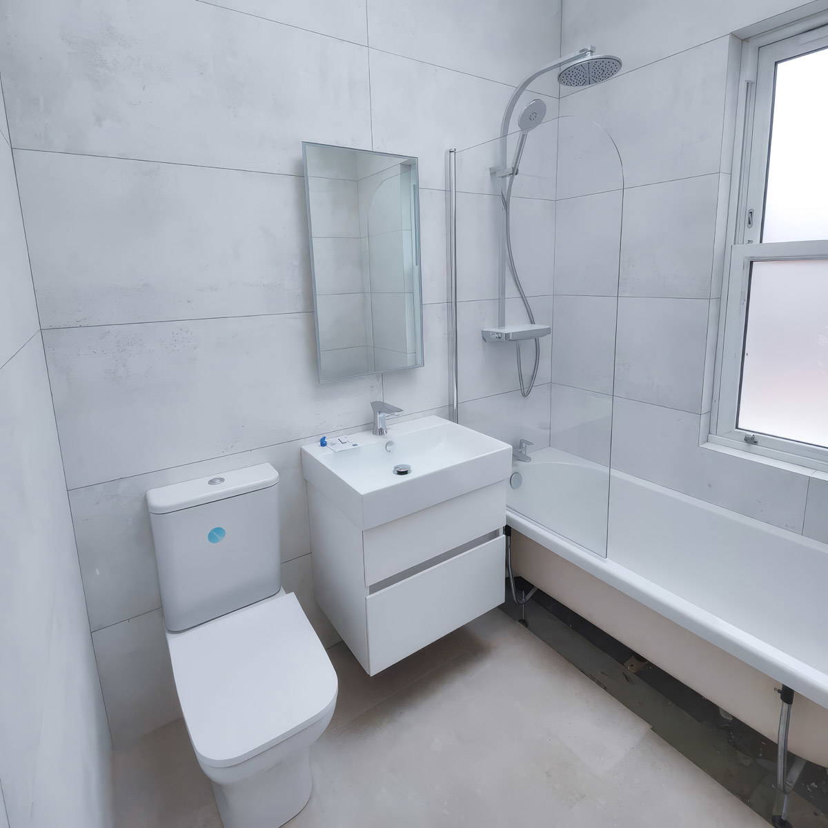 A professional trade tiler accurately leveling large format porcelain wall tiles in a luxury bathroom.