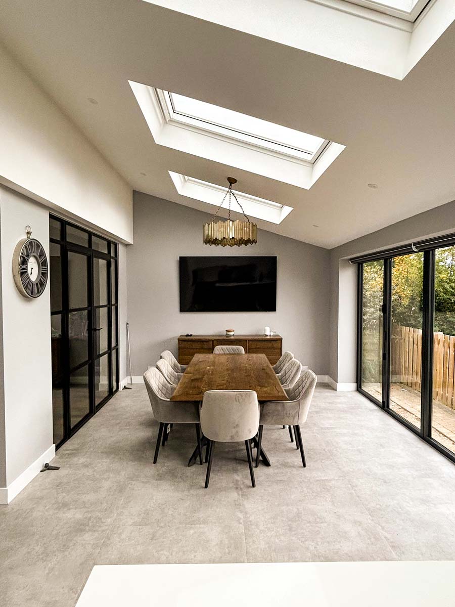 modern single storey rear kitchen house extension in Stockport featuring open-plan bifold doors opening into a garden.