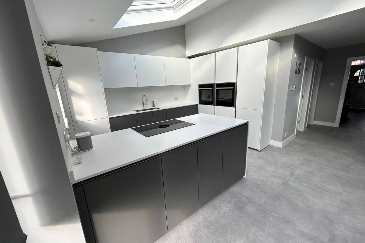Professional kitchen fitters carefully installing high-end kitchen cabinets and solid quartz worktops.